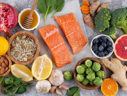 A top view of immunity-boosting foods, featuring vegetables, fish, and a variety of functional foods, including probiotic-rich and brain-boosting options