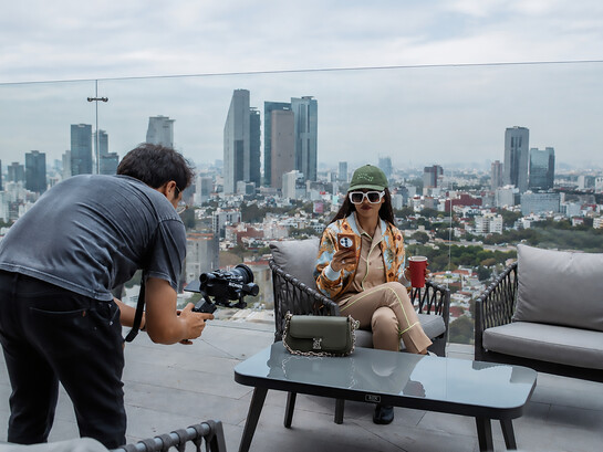 A fashion influencer is filmed on a rooftop terrace overlooking the skyline of Mexico City, Mexico