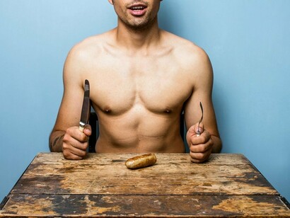 Un hombre desnudo sentado a la mesa