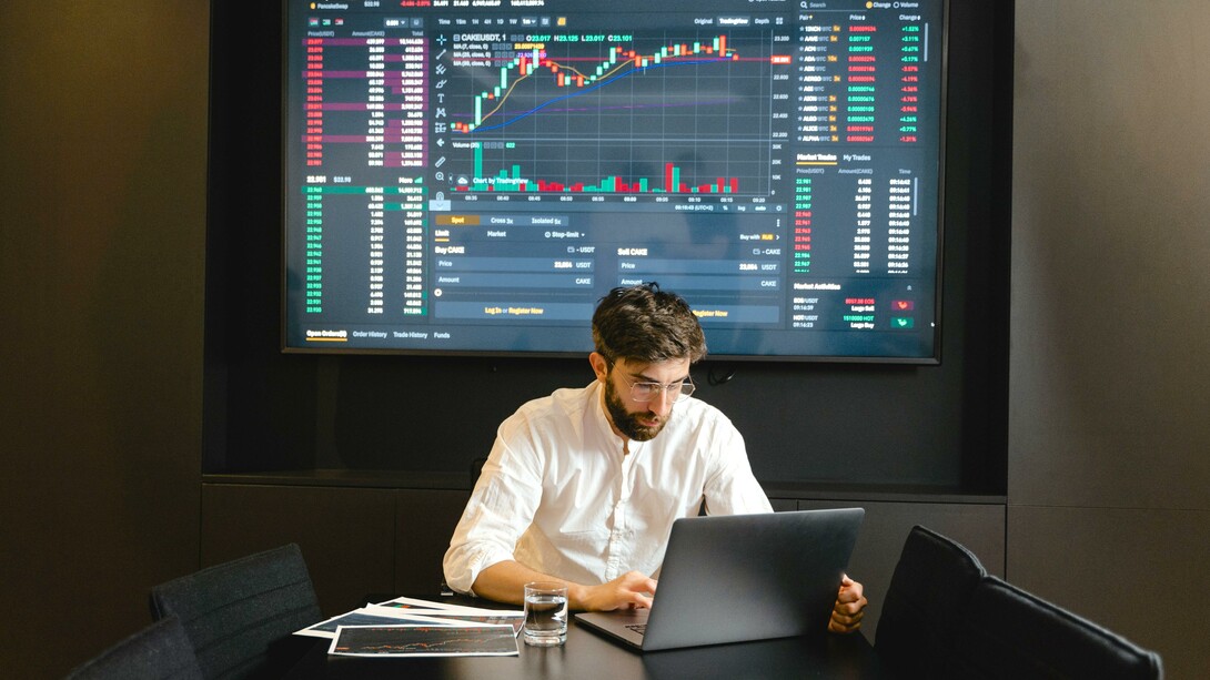 Trader analisando gráfico da bolsa de valores no laptop