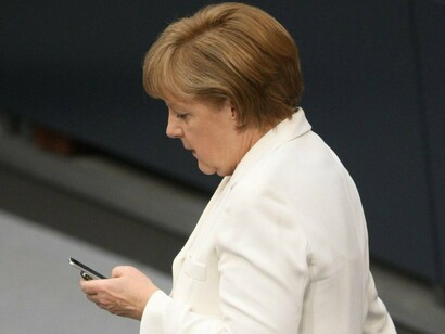 La canciller alemana, Angela Merkel, consultando su teléfono móvil