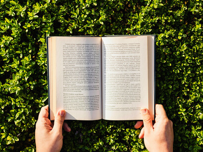 A hand holding the book, representing the power of knowledge and the ability to transport oneself and connect to different worlds