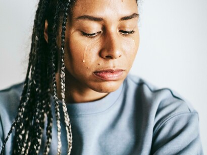 A woman's sentiment revealed in the form of a single tear dripping down her cheek