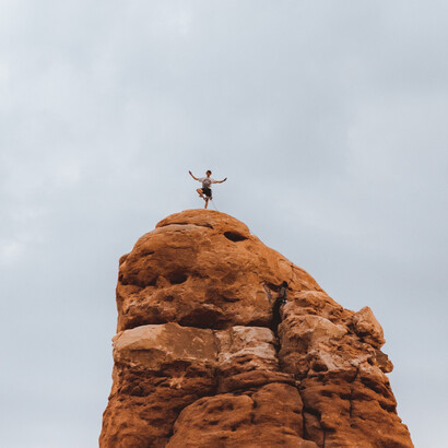 Homem faz pose em cima de rocha após longa escalada