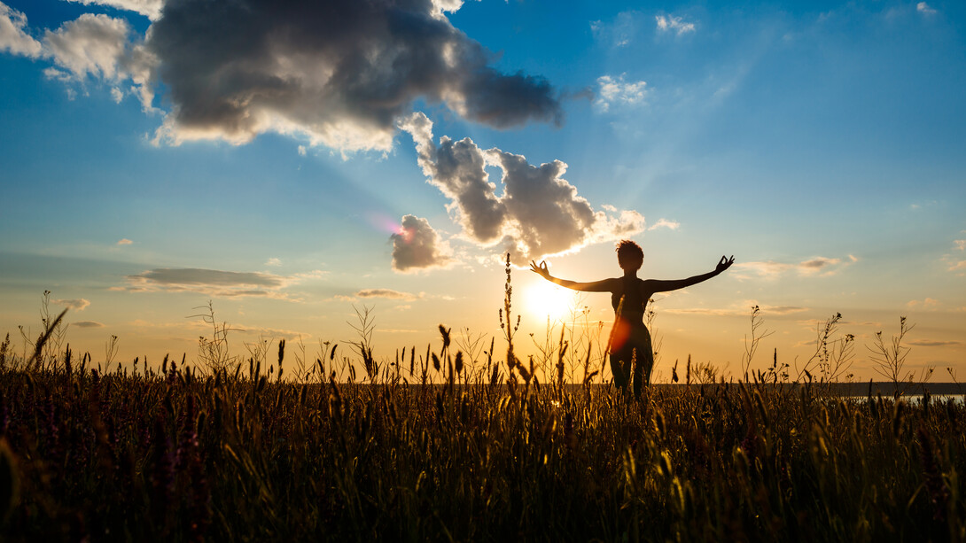 Donna che pratica yoga in un campo all'alba: "... spesso capita di pensare che “basterebbe così poco” per disinnescare processi che si ripetono e che risultano disfunzionali per noi, per la nostra esistenza, ma anche spesso per l’ambiente che ci circonda e in cui viviamo"