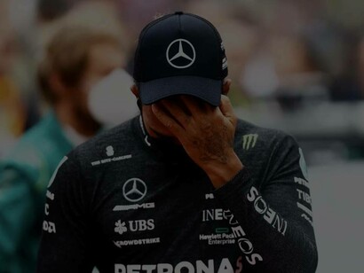 A heartbroken Lewis Hamilton hides his face after a disappointing race