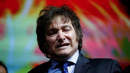 Close up of President Javier Milei on stage, with his iconic ''wig'' of messy hair