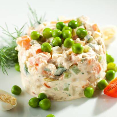 Ensalada de gallina con guisantes, eneldo, huevo sancochado y tomate de adorno