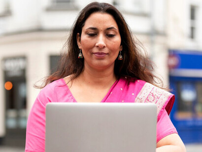 An Indian woman engages with her computer, embodying the spirit of modern innovation and the evolving role of women in technology