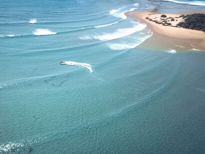 A boat riding in the middle of the beautiful blue ocean, at Tofo beach, Mozambique