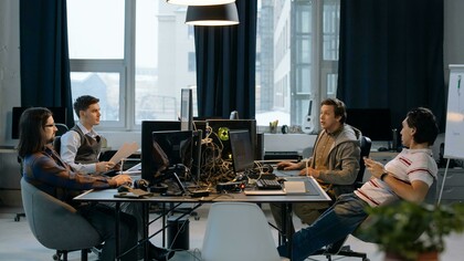 Quatro homens trabalham em frente a computadores num ambiente de escritório. A baixa diversidade nas equipas que desenvolvem inteligência artificial é apontada por especialistas como um dos fatores que contribuem para pontos cegos e vieses nos sistemas. O artigo discute como as escolhas de quem cria a IA influenciam os resultados produzidos pelos algoritmos. A predominância masculina em áreas ligadas à inteligência artificial continua a ser um desafio para a diversidade de perspectivas no setor