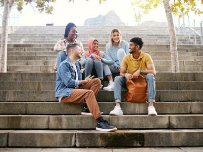 A group of students sits on the stairs, talking about their goals and dreams for the future