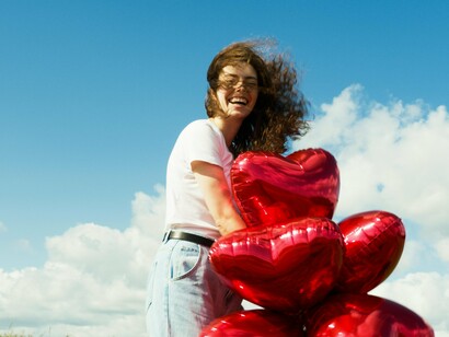 Mulher com balões em forma de coração. Lacan argumentava que o desejo humano é perpetuamente insaciável, sempre buscando algo que está fora de alcance. O amor, neste contexto, é uma tentativa de preencher essa falta, de encontrar no outro aquilo que nos falta. No entanto, essa busca é inevitavelmente frustrada, pois o objeto do desejo nunca pode realmente preencher o vazio interior