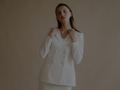Stylish portrait of a young woman showcasing elegant luxury fashion in neutral colors