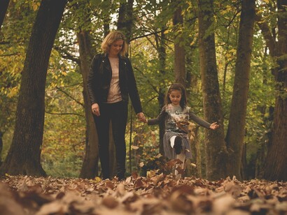 Una madre pasea con su hija en una tarde de otoño