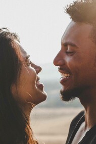 Man and woman gaze at each other by the beach