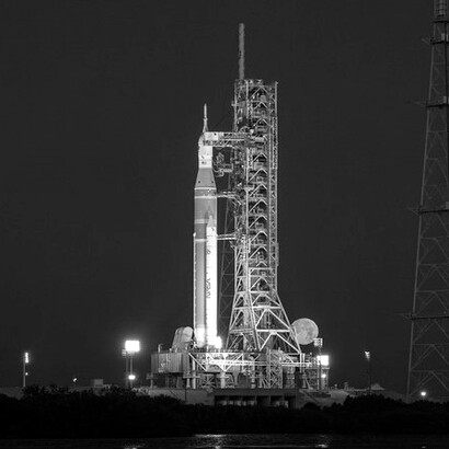 La luna piena è visibile dietro il razzo Space Launch System (SLS) della missione Artemis II della NASA e la navicella spaziale Orion, posizionati su una piattaforma di lancio mobile presso il Complesso di Lancio 39B, domenica 1 febbraio 2026, al Kennedy Space Center della NASA in Florida. Crediti fotografici: NASA/John Kraus