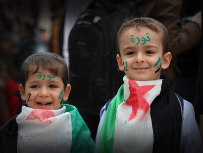 Niños palestinos sonríen con la bandera de su nación