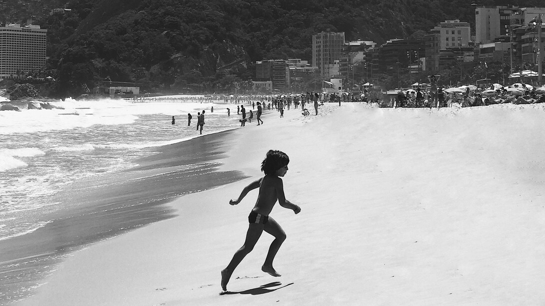 Fotografia dos anos 1990 na praia do Rio de Janeiro, Brasil e o retrato da infância que se desenvolvia aos sons de samba, ponto de macumba, ritos, cuidados domésticos e a presença de mulheres negras meio à ascensão da burguesia