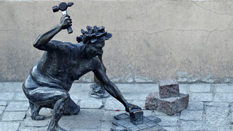 Statue of a mason, using his hammer on the walkway