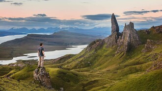 A man standing in a mountainous region wondering how to create a better world