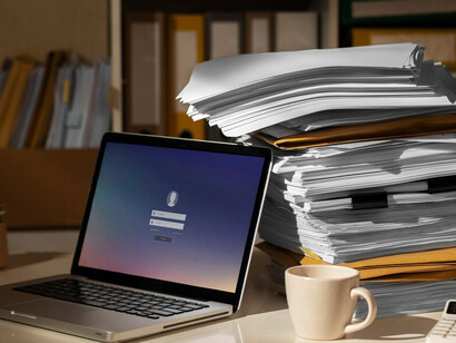 The table is covered with a pile of documents and papers, showcasing unfinished and messy drafts