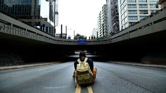 Homem fotografa placa que dá nome a um túnel. Será que alguma pessoa tem mérito suficiente para ser nome de rua? Muitos feitos heroicos ou significativos se dissipam com o tempo, ficam ultrapassados e, até mesmo, o que foi muito importante e valioso numa ocasião, em outra época pode ser irrelevante
