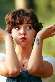 A playful woman outdoors striking a whimsical pose