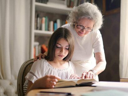 Grand-mère aidant sa petite-fille à faire ses devoirs. Dans le cas de ma grand-mère, je me sens chanceuse car elle est très entourée, elle est donc “immunisée” contre les escroqueries © Sacha Jea