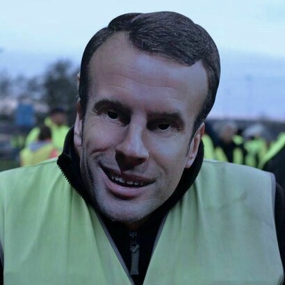 Un manifestante con una careta de Macron