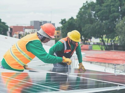Workers screwing in solar panels which were a direct result of linear innovation