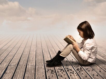 Una niña leyendo al aire libre