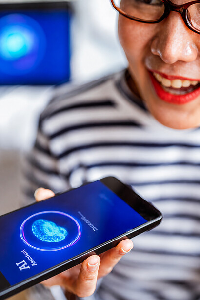 A close-up of her hand holding the device as a cheerful woman smiles, while an AI assistant analyzes visual input and delivers insights, supporting her in organizing and planning within a seamless modern lifestyle