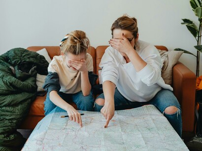 A mindful travel moment as a woman and her daughter explore destinations together on a map