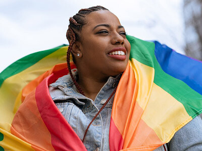 Woman holding a rainbow LGBTQIA+ flag