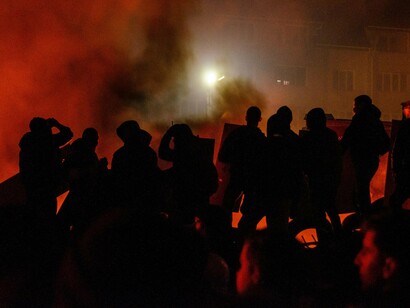 A protest scene engulfed in fire and smoke, symbolising the eruption of long-simmering tension
