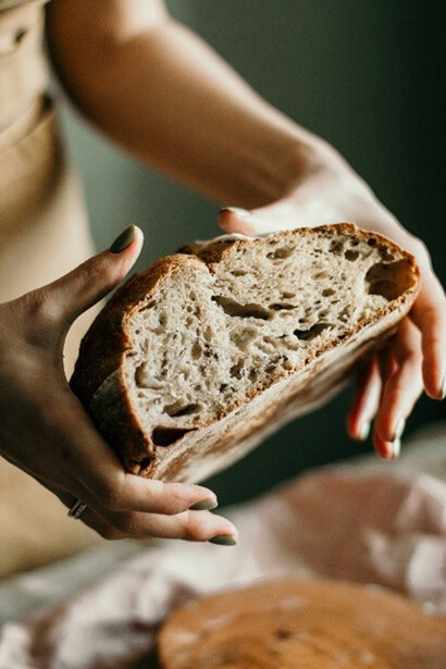 Woman holding freshly baked sourdough bread