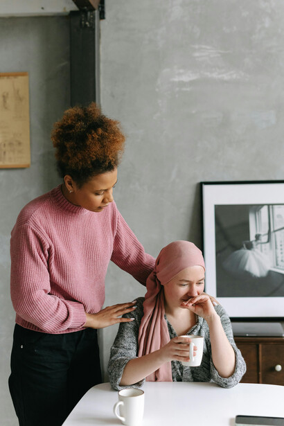 Two women holding hands, symbolizing strength and resilience in the face of cancer