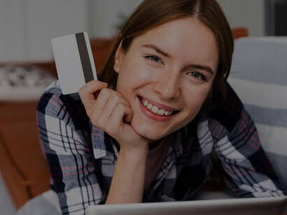 Amidst the pandemic-driven surge in digitalization, a woman engages in online shopping, browsing her tablet while holding a credit card, exemplifying the rapid adoption of e-commerce during COVID-19