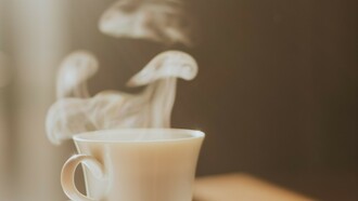 Vapeur s'échappant d'un café servi dans une tasse en porcelaine, peut-être celle d'un hôtel de luxe