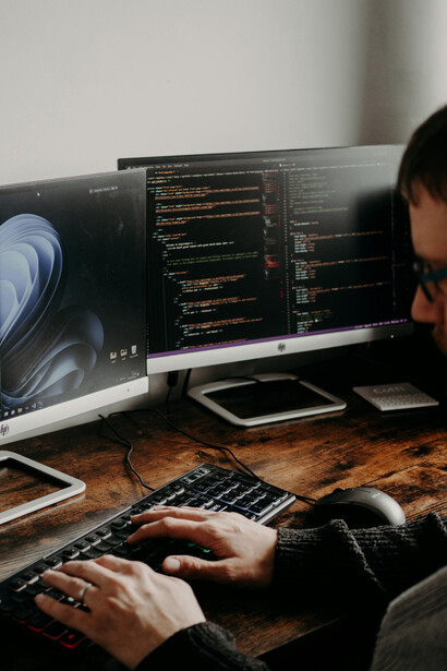 A man working at his computer, engaged in software coding