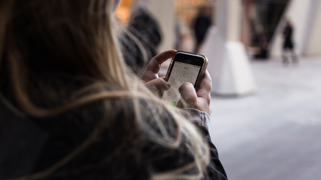 Una mujer teclea un número en su móvil