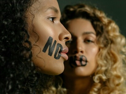 Two women with “no” written across their faces, representing the quiet strength of setting boundaries