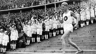 Un relevo acarrea el fuego durante los Juegos Olímpicos de Berlín, 1936