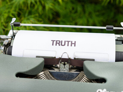 A typewriter typing the words, "truth"