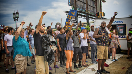 Raised fists of the people protesting together symbolize resistance and the fight against power