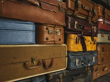 Malas antigas empilhadas em um ambiente rústico remetem à preparação para uma viagem e à expectativa pelo que está por vir. Antes de conhecer um lugar diferente, é preciso deixar para trás, ainda que temporariamente, aquilo que nos é familiar