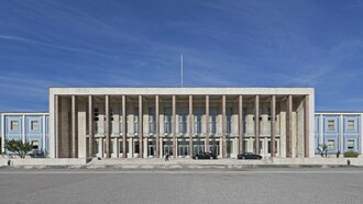A fachada monumental da Faculdade de Letras de Lisboa ergue-se como templo moderno da cultura e da memória ocidental. Entre colunas, painéis e simetrias, a arquitectura converte-se em linguagem simbólica do conhecimento