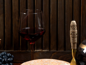 Round cheddar cheese served with grapes and wine, a classic pairing