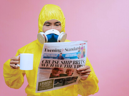 Homem utiliza máscara de respiração enquanto lê o jornal